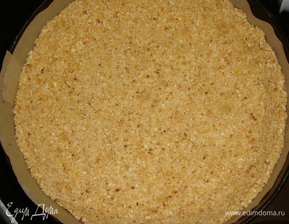 Форму для выпечки (у меня 26 см) застелить пергаментом и выложить печенье, утрамбовать ложкой, делая бортики 2 см. Убрать в холодильник пока делаем начинку.