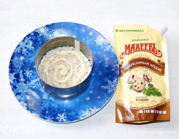 Берем сервировочное блюдо и ставим на середину формовочное кольцо. Дно смазываем майонезом ТМ «МахеевЪ» и выкладываем куриное филе, смазываем майонезом.
