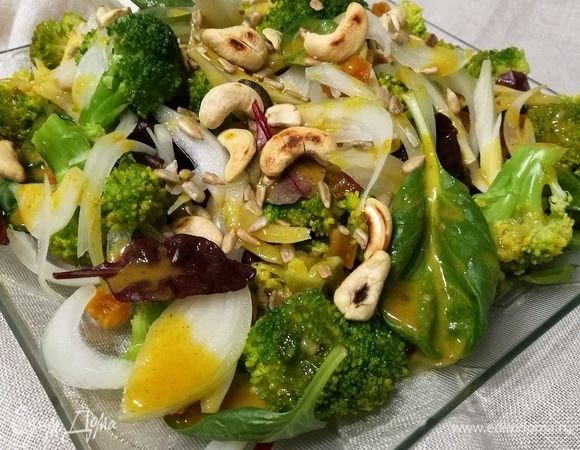 Выложить на тарелку салатный микс, брокколи, лук, мелко нарезанную курагу, орешки и семечки. Полить заправкой.  