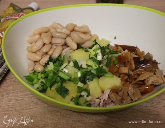 Добавить консервированную фасоль и мелко нарезанные зеленый лук и петрушку.
