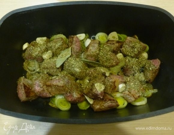 В кастрюлю добавить мелко нарезанные лук, чеснок, рубленые стебли петрушки, лавровые листья, орегано, мяту, корицу и душистый перец.