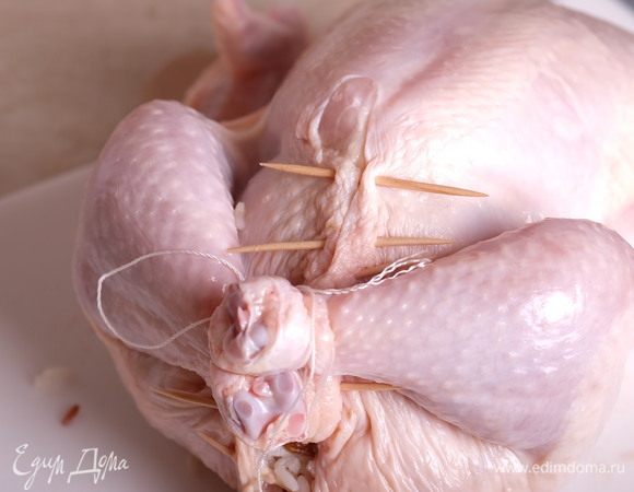 Заколоть брюшко курицы зубочистками или зашить нитью, ножки связать нитью.