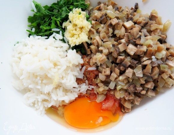 Зелень петрушки мелко нарезать, чеснок пропустить через чеснокодавку. Добавить к фаршу остывшие грибы, чеснок, петрушку и яйцо. Посолить и поперчить по вкусу, хорошо перемешать.