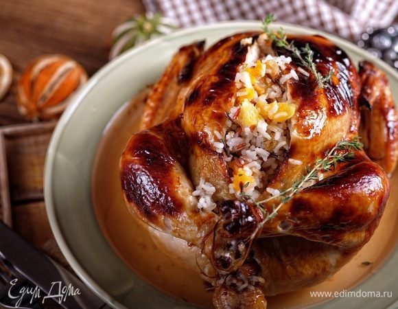 Готовую курицу немного охладить, разрезать кухонными ножницами вдоль груди, выложить рис, курицу разделить на порционные куски. Подавать горячей.