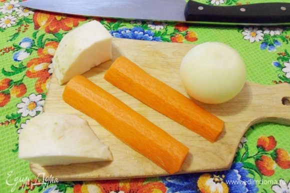 Пока мясо закипает, подготовить овощи. Очистить и промыть репчатый лук, морковь и корень сельдерея. Морковь, лук и корень сельдерея разрезать на две части.
