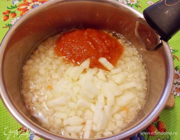 Добавить мелко нарезанный репчатый лук и томатную пасту. Закрыть кастрюлю крышкой и тушить на медленном огне до полной мягкости капусты. 