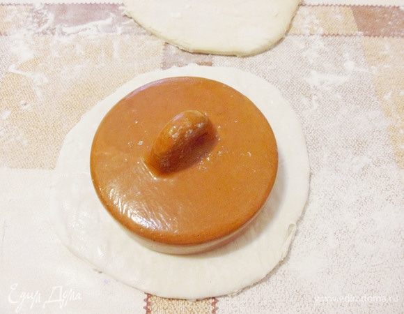 Вырезать из квадрата круг немного большего размера, чем диаметр горшочка.