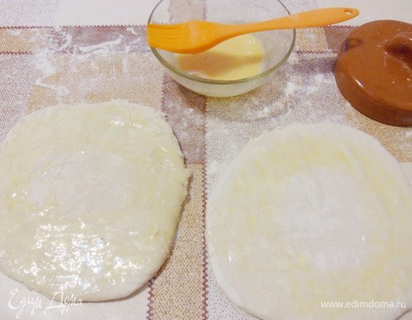 Круги теста перевернуть, смазать края взбитым яйцом.