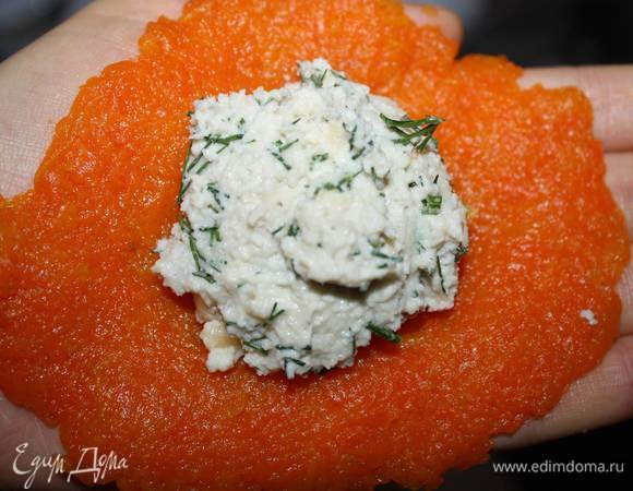 Берем одну часть морковного пюре. Формируем круглый пласт на ладони. Выкладываем по середине начинку. 