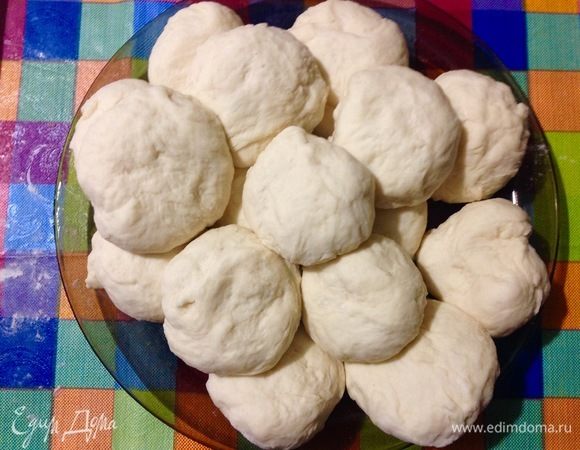 Теперь снова, подсыпая малюсенькими щепотками муку, обминаем тесто, так чтобы из него выходил воздух, вы будете чувствовать, как под руками лопаются пузырьки с воздухом.
Делим комок теста на 16 частей, каждую часть выкатываем в колобок.