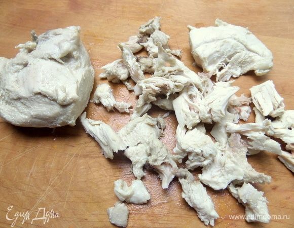 Вынуть курицу и нарезать мелко, отделив от костей.