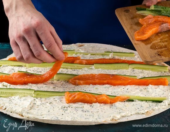 Выложите полоски нарезанной семги и огурца.