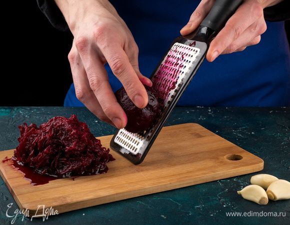 Отварите свеклу и натрите ее на средней терке. Измельчите чеснок.
