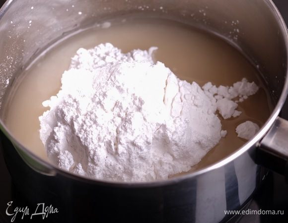 В глубокий сотейник налить воду и добавить сахарную пудру.