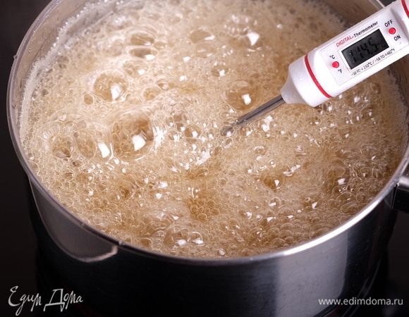Не мешая, варим сироп до температуры 135°С. Важно взять высокий сотейник, потому что после добавления меда смесь начнет очень сильно пузыриться и поднимется.