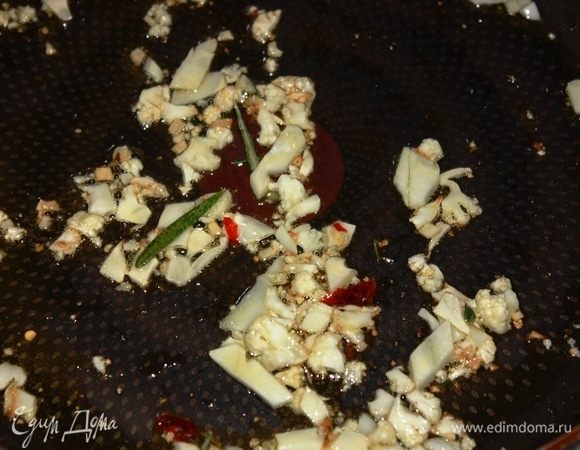 На разогретую сковороду на маленьком огне выложить тонко и мелко нарезанные соцветия свежей цветной капусты, 1 измельченный зубчик чеснока, 3–4 листика розмарина, 3–4 листика тимьяна, 1/3 сушеного или свежего острого перца чили (он же, пеперончино), обжарить, периодически помешивая, до готовности цветной капусты. Капуста не должна быть очень мягкой, но и не твердой. Она должна получиться полусырой.