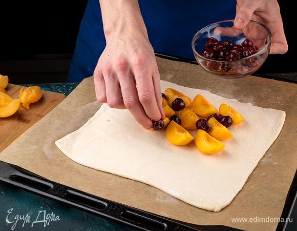 Раскатайте пласт слоеного теста переложите на застеленный пергаментом противень. Выложите фрукты на слой теста.
