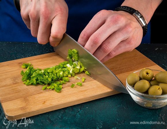 Нашинкуйте зеленый лук. Оливки порубите колечками.