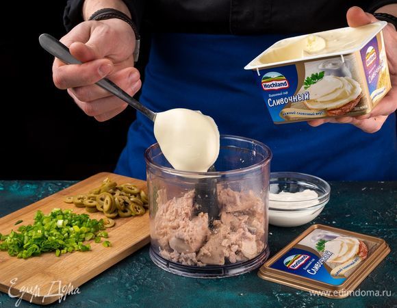 Выложите печень трески с зеленым луком и оливками в чашу блендера, добавьте плавленый сыр Hochland сливочный в ванночке и сметану. Добавьте оливки и лук.