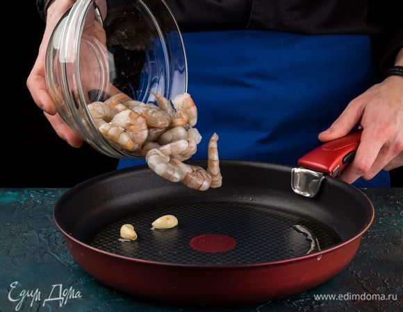 Обжарьте на раскаленной сковороде с оливковым маслом очищенные зубчики чеснока до золотистого цвета. Разморозьте и очистите креветки, подрумяньте буквально пару минут в чесночном масле.