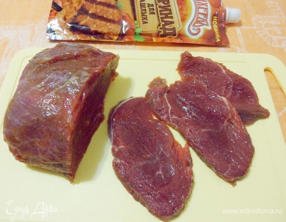 Убрать излишки маринада бумажной салфеткой. Говядину нарезать тонкими ломтиками поперек волокон.