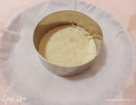 Форму для запекания застелить пекарской бумагой. На дно порционного кольца положить хлебные крошки. 