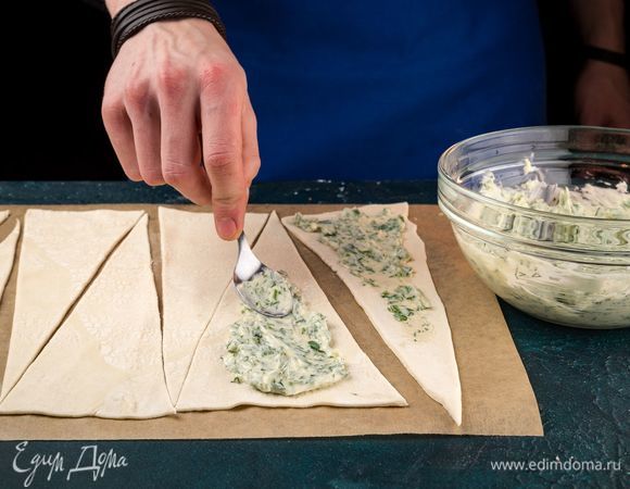 Каждый треугольник смажьте сырной начинкой, отступив место от краев по 2 см.