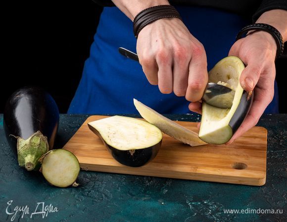 Срежьте у баклажанов плодоножки, разрежьте вдоль пополам, удалите сердцевину. Замочите в соленой воде на полчаса.