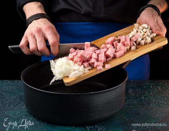Измельчите лук и грибы. Нарежьте мелким кубиком ветчину, добавьте к луку с грибами и обжарьте все до золотистого цвета.