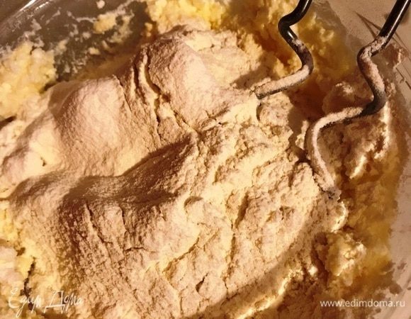 Постепенно небольшими порциями добавить просеянную муку и разрыхлитель.