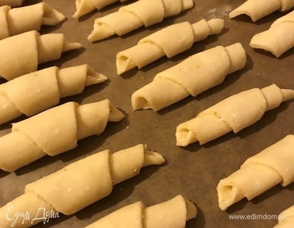 Выложить на застеленный пергаментом противень и выпекать 10–15 минут в предварительно разогретой до 180°С духовке до золотистого цвета. Готовые рогалики посыпать сахарной пудрой.