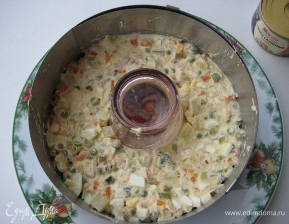 На сервировочное блюдо поставить разъемное кольцо d=20 cм, в центр поставить стакан. Выложить салат, примять лопаткой. 