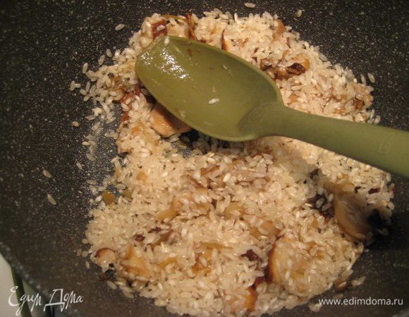 Всыпать рис (у меня сорт арборио), рис не промывать. Помешивая готовить 2 минуты. Влить сухое белое вино, дать алкоголю выпариться. Теперь влить два половника бульона, перемешать. Ризотто необходимо во время приготовления постоянно помешивать, рис готовится около 16 минут, подливать по половнику горячий бульон по мере его впитывания.