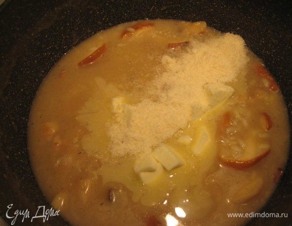 Порезать кубиком холодное сливочное масло. Когда рис будет готов, снять ризотто с огня, добавить холодное сливочное масло и тертый пармезан и тщательно перемешать до растворения сыра и масла. Накрыть крышкой и дать постоять 5 минут.