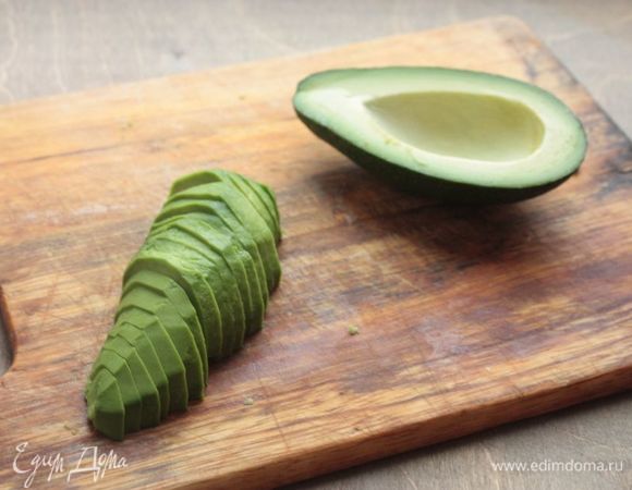Из авокадо удалите косточку, а также очистите от шкурки. Нарежьте дольками толщиной 3–4 мм.