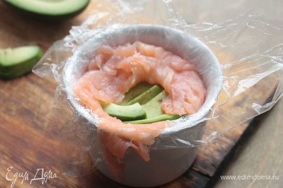 Поверх риса уложите авокадо и накройте его лососем так, чтобы рыба полностью закрывала начинку.