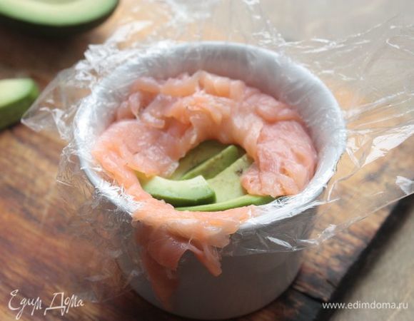 Поверх риса уложите авокадо и накройте его лососем так, чтобы рыба полностью закрывала начинку.