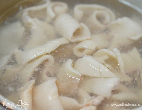 Положите кальмары в кипящую подсоленную воду на 1 минуту, затем промойте холодной водой. Кальмары свернутся и станут похожи на шишки.