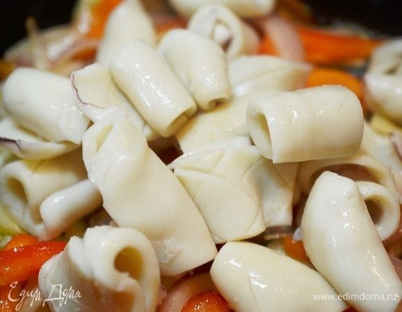 Добавьте к овощам кальмары.