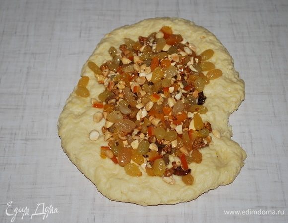 Растянем тесто и посыпем  изюмом, цукатами и порезанным миндалем, я добавила немного грецких орехов.