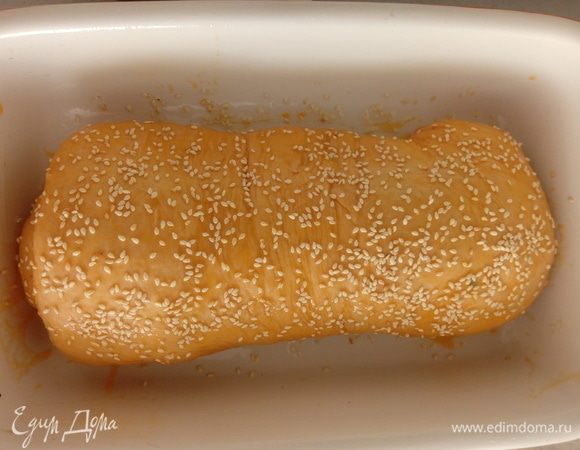 Затем сворачиваем в рулет, кладем в форму смазанную маслом. Смазываем желтком и посыпаем обжаренным кунжутом. Оставляем для расстойки в теплом месте на 20-30 минут. Выпекаем в духовке при 200°С 30-40 минут.
