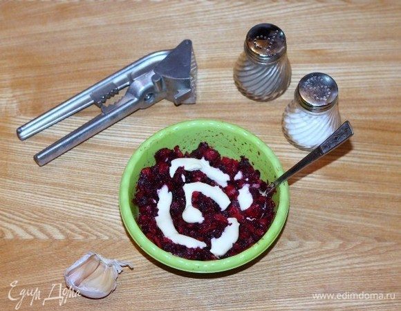 Свеклу, морковь и яйца отварить и охладить. Свеклу и морковь очистить, натереть на крупной терке и смешать. Добавить майонез, прессованный зубчик чеснока, соль и перец, перемешать.
