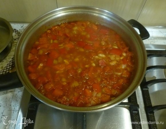 Лук, перец порубить. Разогреть оставшееся масло в большом сотейнике, готовить на слабом огне лук, чили (по желанию), перцы с оставшимися специями 15 минут, помешивая. Добавить фасоль с жидкостью, томаты. Тушить 30 минут.