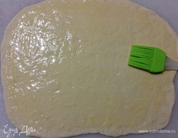 Берем одну часть — 1 колобок, остальные 2 накрываем полотенцем, чтобы не обветривались и раскатываем колобок в пласт, пласт смазываем растопленным, не горячим сливочным маслом.
