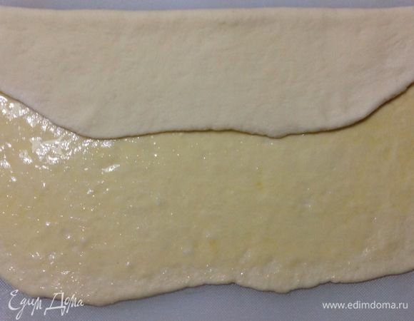 Теперь надо сложить пласт теста как это делается в процессе с бездрожжевым слоеным тестом — сложить книжкой. Одну половину что вдоль пласта складываем к центру как на фото.