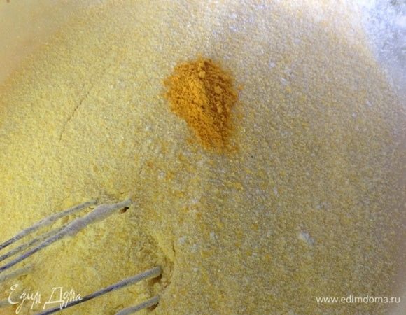 Просеиваем в миску теперь кукурузную муку, добавляем куркуму.
Замешиваем.