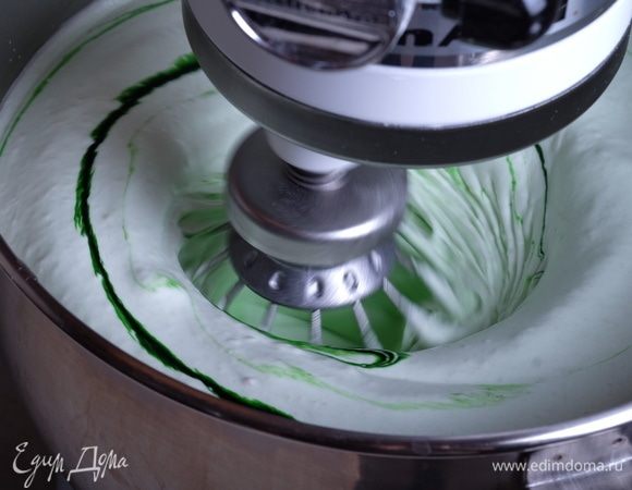 Не выключая миксера, начинаем тонкой струйкой вливать сироп во взбивающееся пюре. Лить нужно по стенке чаши, но лучше-в пространство между чашей и двигающимся венчиком — тогда сироп не будет разбрызгиваться и весь он попадет в массу. Если сироп сварен правильно, то он будет совершенно однородный, прозрачный и «текучий». Весь сироп влили, добавляем каплю зеленого красителя, взбиваем массу еще минут 5-7.