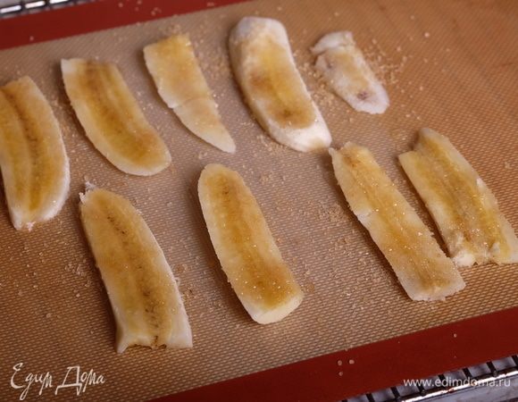 Готовим карамелизованные бананы. Разогреть духовку до 210°С. Бананы разрезать вдоль на полоски толщиной 5 мм, выложить на силиконовый коврик, сбрызнуть соком лайма и посыпать коричневым сахаром.