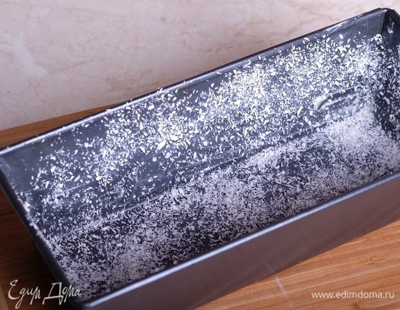 Готовим кекс. Духовку разогреть до 160°С. Форму для выпечки обильно смазать сливочным маслом и присыпать дно и стенки кокосовой стружкой.