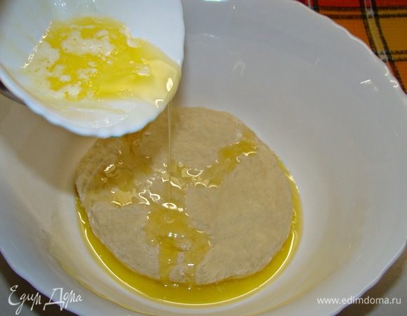 В замешанное тесто влить растопленное сливочное масло и хорошо вымесить. Поставить в теплое место примерно на час. 